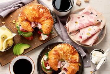 ..Croissant with ham and cheese on board and plate. Breakfast concept.