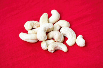 Tasty cashew nuts, raw cashews on a red background. In the Bengali language, it is called Kaju Badam.
