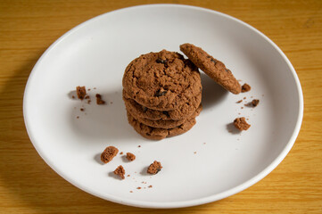 sweet chocolate biscuits on a white plate with a wooden patterned background