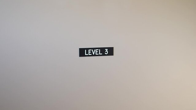 Sign Indicating Level 3 on a Plain Wall