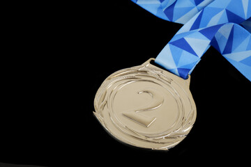 Silver medal with ribbon isolated on black background. Copy space for text.