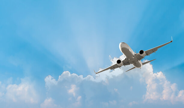 White passenger airplane flying in the sky amazing clouds in the background - Travel by air transport