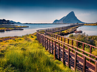 Marvelous summer view of Spiaggia di Porto Taverna beach with wooden footpath bridge. Superb...