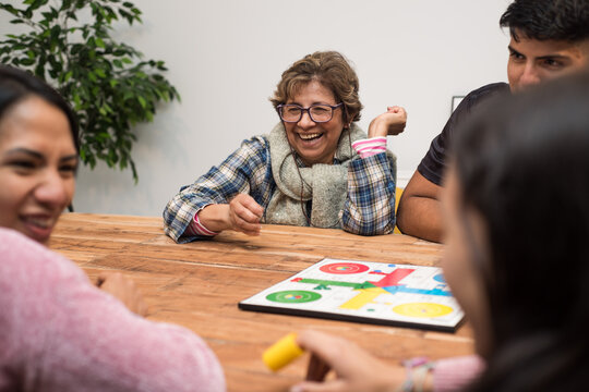 Multi generational family having fun playing ludo at home