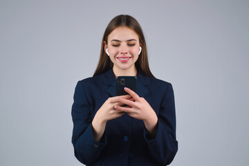 Business woman using phone chatting online. Girl using smartphone. Businesswoman with phone in studio. Business call. Young Woman in suit chatting on phone. Student tell on phone.
