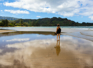 Female Tourist and  Reflection on Hanalei Beach, Hanalei, Kauai, Hawaii, USA