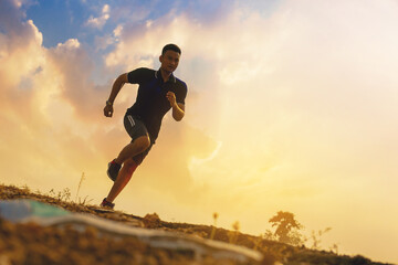 Silhouette of young man running sprinting on road. Fit runner fitness runner during outdoor...