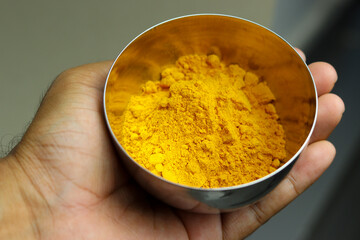 Close up of Turmeric powder in stainless steel bowl.