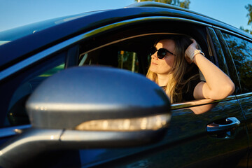 Woman wearing sunglasses is driving car