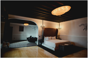 cuarto de hotel con una tina y una cama, piso de madera, puebla