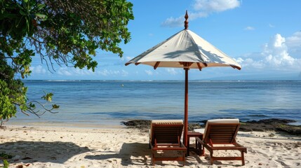 A beautiful beach background for a summer trip. Bright sun, palm tree and beach chairs on the sand against a beautiful blue sea and blue sky.