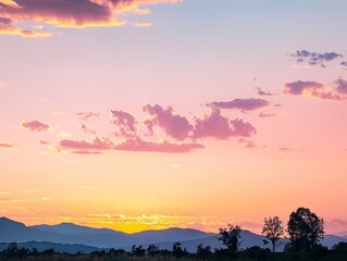 Sunset sky in the morning with sunrise and soft pink clouds with yellow tones, with silhouettes of distant mountains and trees in the foreground, adding contrast and emphasizing the peacefulness of