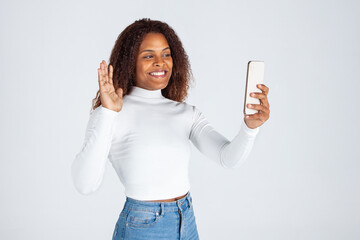 Chica negra afro usando teléfono móvil. Mujer haciendo selfies. Fotografia con móvil....