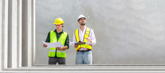 Engineer and foreman worker team with blueprints checking project at the precast concrete factory...