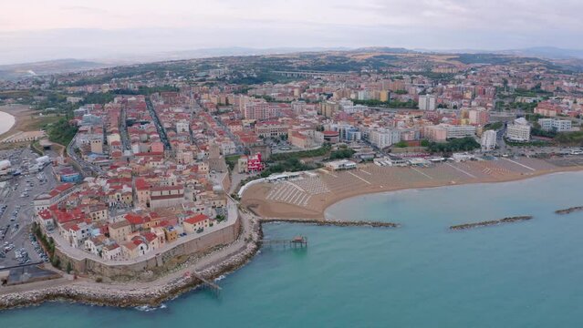 4k drone flight moving to the side footage (Ultra High Definition) of Sant'Antonio beach. Exciting morning cityscape of Termoli port. Spectacular sunrise on Adriatic sea. Traveling concept background.
