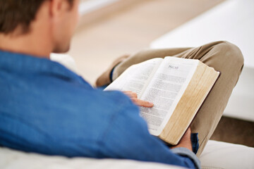 Fototapeta premium Christian, gospel and hands reading bible in living room to worship God, faith or praise Jesus Christ in home. Spiritual, holy book and person studying scripture story on sofa for learning religion