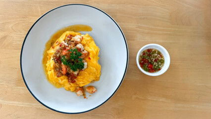 Top view.Shrimp omelet with parsley sprinkled on a white plate and Chilli and Fish Sauce.