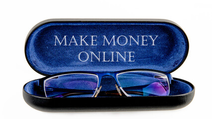 Business concept. MAKE MONEY ONLINE lettering written on an open case with eyeglasses