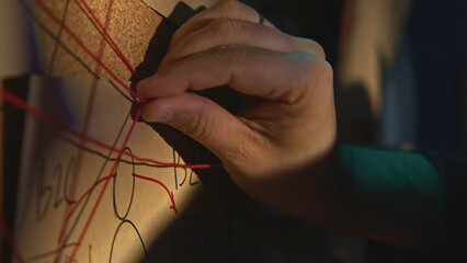 Close-up of board with notes and threads. Stock footage. Man is investigating and fixing evidence...