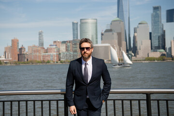 Confident success business man executive standing in New York City. Business American success. American business dream. American businessmen in suits near Manhattan. Successful business in USA.