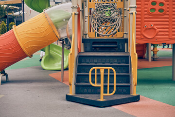 An image of a colorful playground without children. Modern slides and mazes are made of plastic....