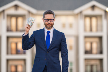 Business man in suit with cash money dollars banknotes outdoor. Hundred dollar bill, financial concept. Real estate investment. Payment concept. Finance, investment and money saving.