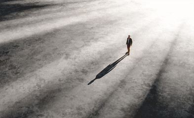 Solitary man walking in vast empty space