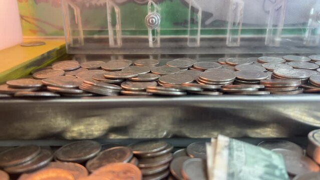Gambling machine with quarters being pushed 4k