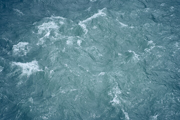 Beautiful background with blue water and a place to copy. Close-up of raging waters. Ripples and...