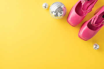 Pink shoes and disco balls set against a vibrant yellow background evoking a fun and festive...