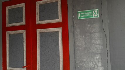 Green emergency exit sign on the wall for evacuation route