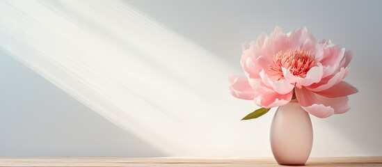 A vintage toned image of a pink peony flower in a vase against a white background of a cozy home providing copy space for your text