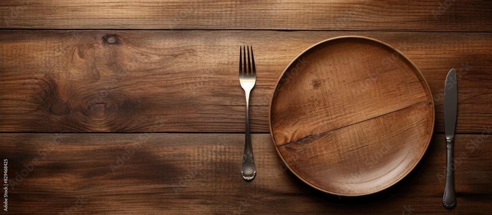 Aufkleber an image of a plate with no food and utensils a spoon and fork placed on a wooden table. copyspace i