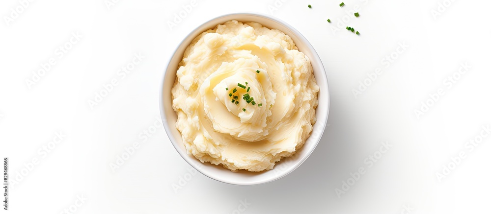 Poster top view of a bowl filled with delicious mashed potatoes providing a white background with enough em