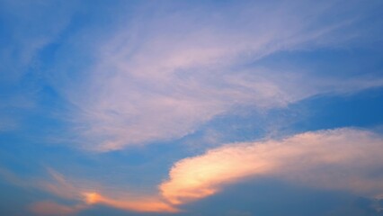 A stunning sunset with a sky transitioning from deep blue to soft pink and orange hues. Wispy...