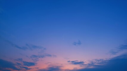 A tranquil evening sky transitioning from deep blue at the top to a soft pink and purple near the...