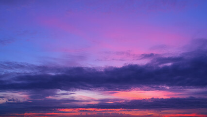A stunning sunrise with a sky transitioning through shades of deep purples, pinks, and blues. The...
