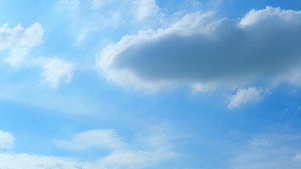A vibrant blue sky adorned with a mix of fluffy white and darker gray clouds. The clouds vary in...
