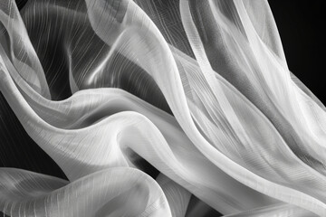 A high-contrast black and white image of a folded fabric with clean, elegant lines 