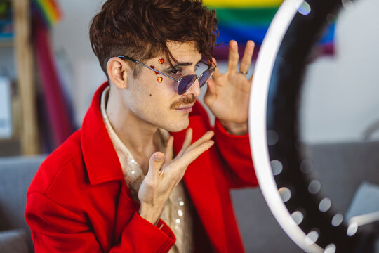 Influencer wearing red blazer and sunglasses gesturing in front of ring light