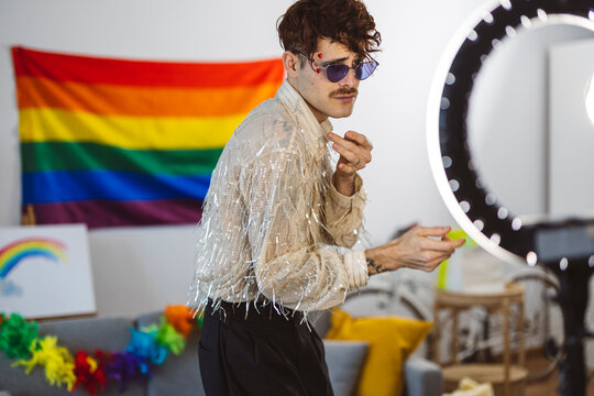 Influencer wearing sunglasses and vlogging in front of ring light at home