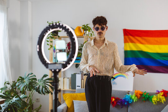 Influencer preparing for pride party and filming through smart phone attached on ring light