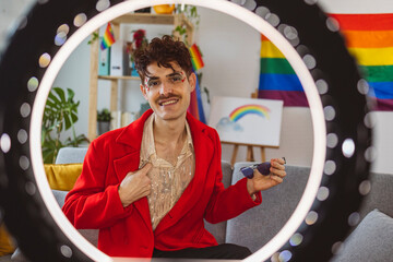 Smiling non-binary person vlogging with ring light at home
