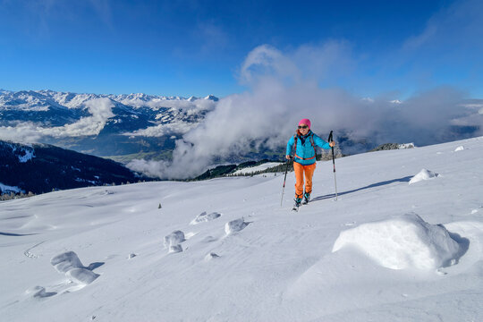 Woman with ski poles back country skiing at Wiedersberger Horn, Kitzbuehel Alps, Tyrol, Austria