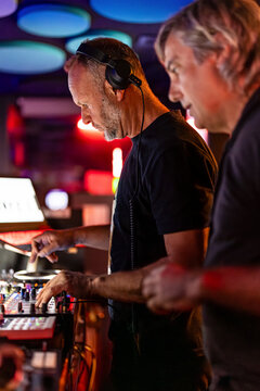 Mature DJs playing music at nightclub