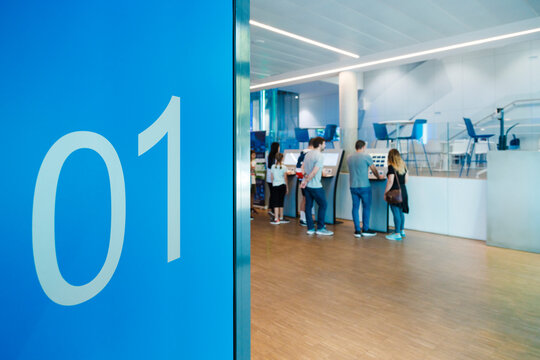 Number 1 on blue wall with people checking-in at entrance hall of indoor skydiving center