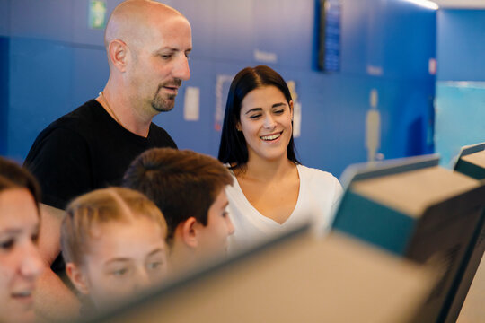 Happy woman and man doing self-service check-in at indoor skydiving center