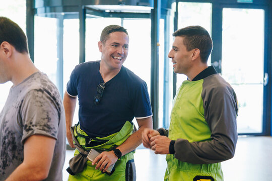 Happy men in sportswear talking at indoor skydiving center