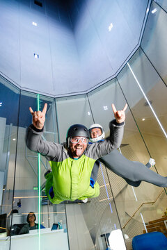 Man sticking out tongue and enjoying skydiving with instructor