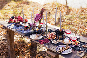 Various food with red wineglasses and candles decorated for thanksgiving at dinner table